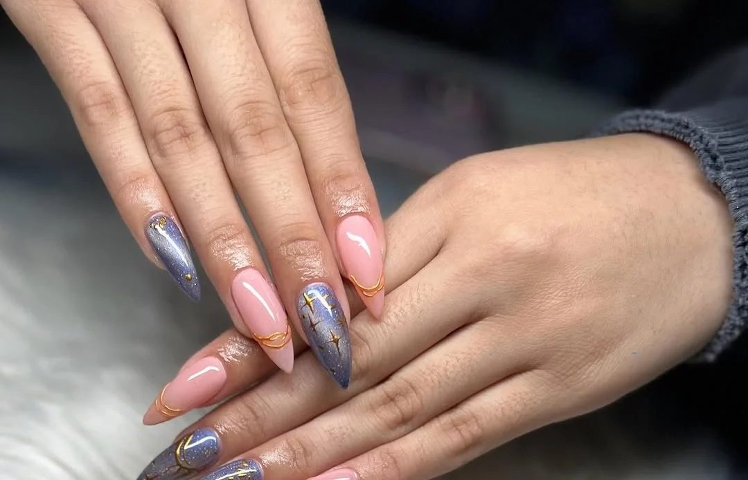 Long almond nails with lavender shimmer, pink bases and gold star accents