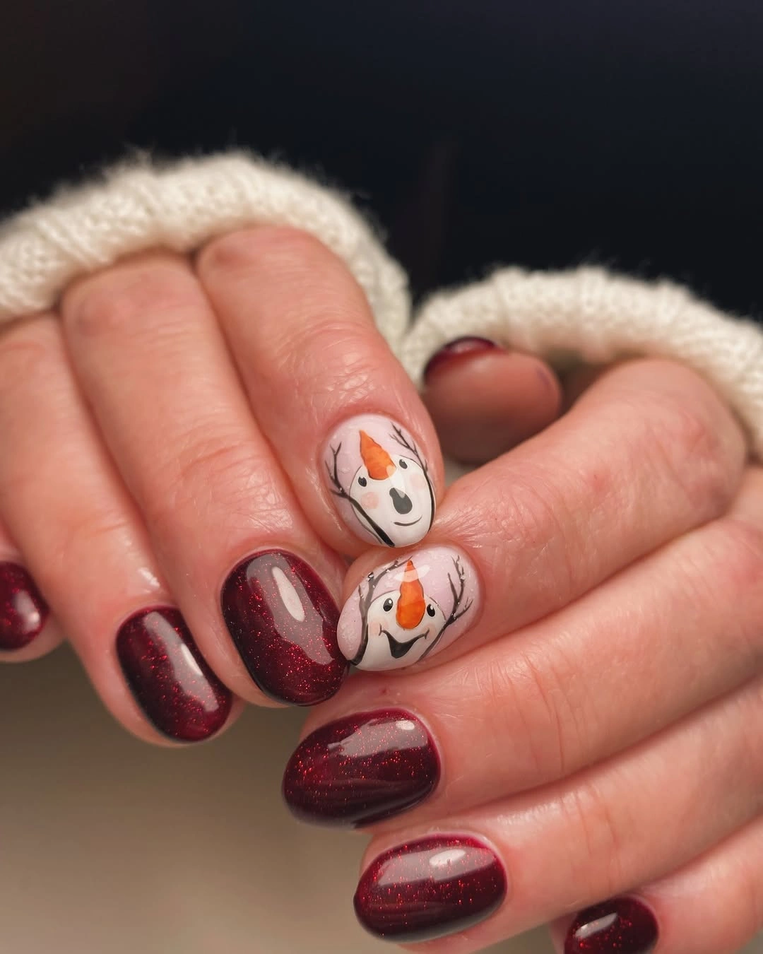 Short red glitter nails with pale snowman face accents