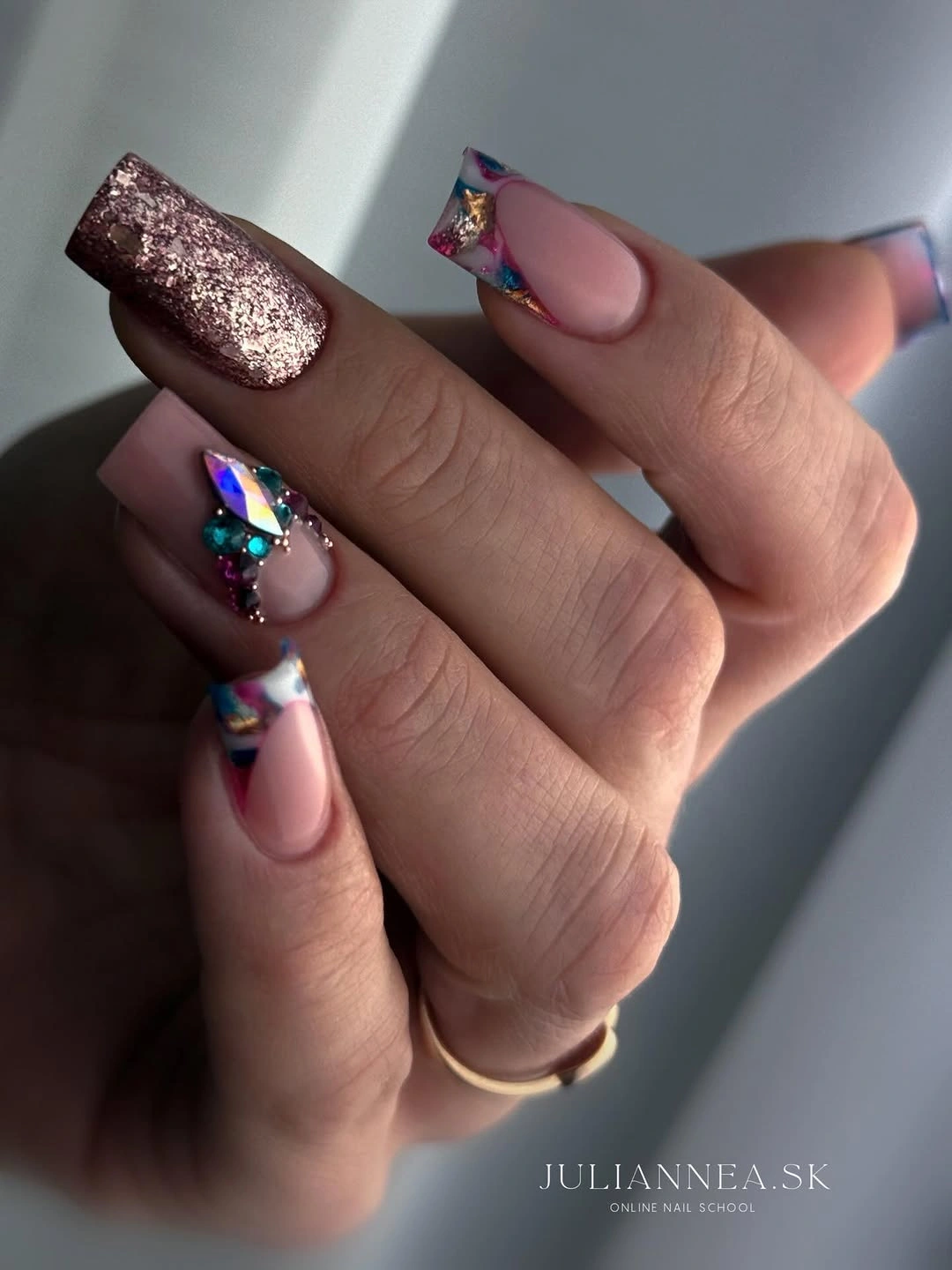 Long square pink nails with rose gold glitter and faceted iridescent decorations