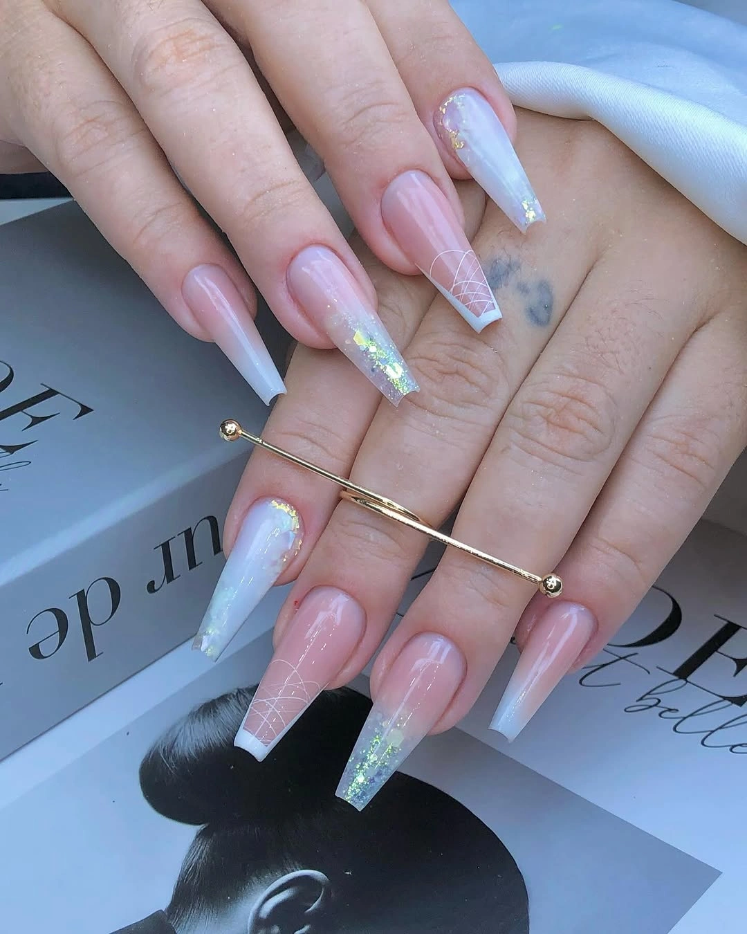 Long tapered square nails with icy blue gradients, iridescent glitter and white lines