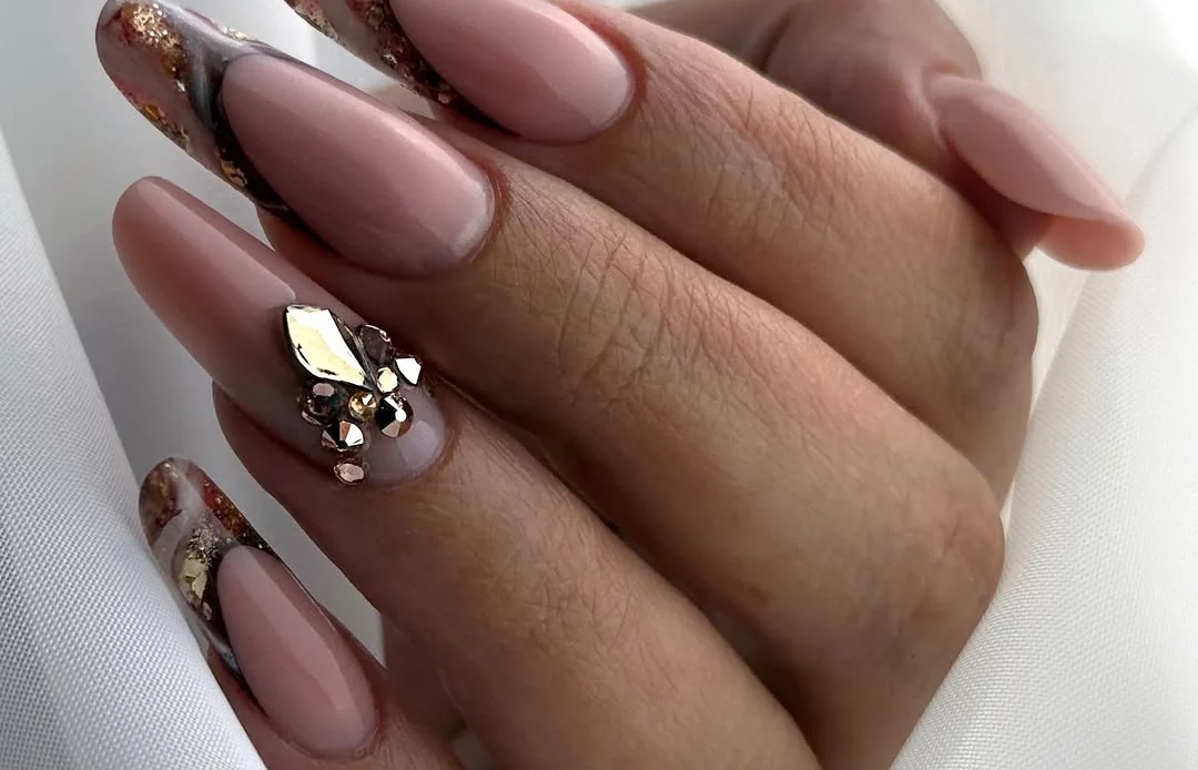 Long pink almond nails with bronze gold edges and clustered reflective accent