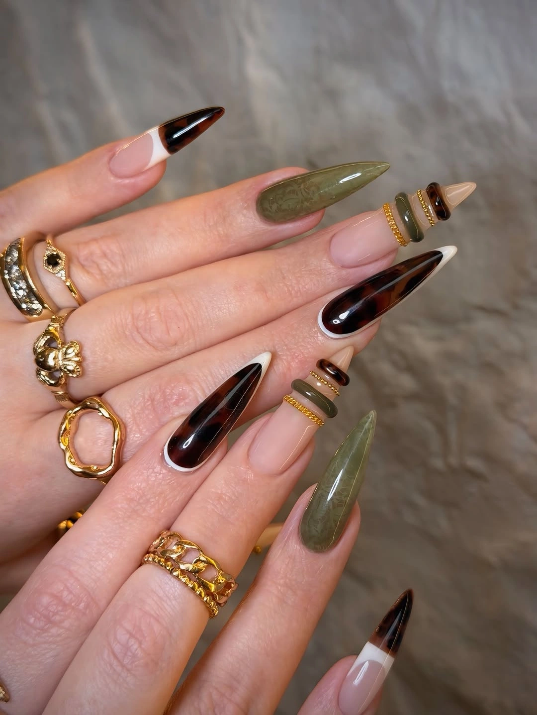 Long pointed nails with olive green polish dark tips and gold accents