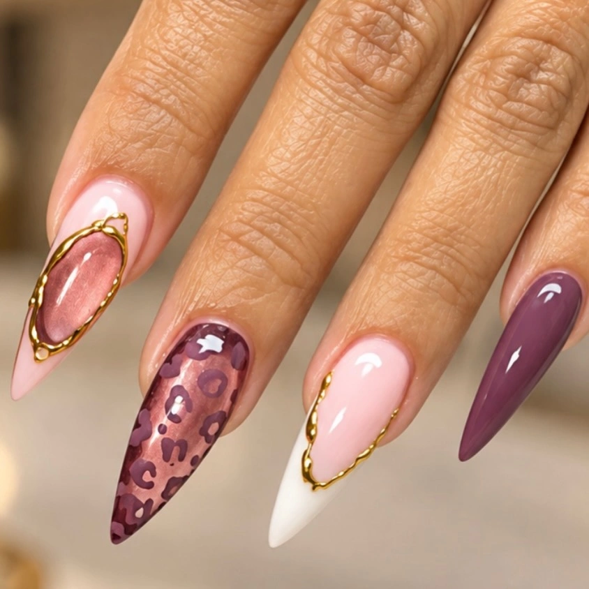 Long pointed mauve and pink nails with leopard spots and gold borders