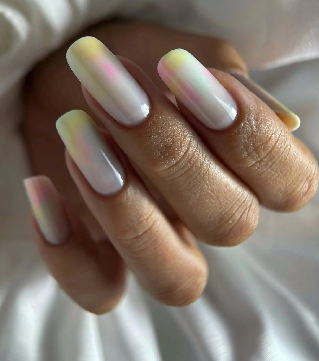 Long square white nails with soft yellow pink mint and blue accents