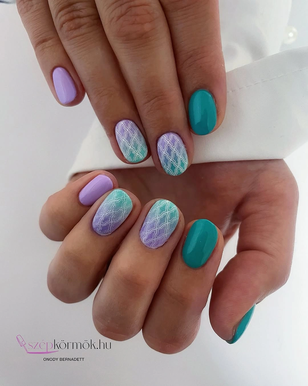 Short oval turquoise and lavender nails with white geometric lattice over gradients