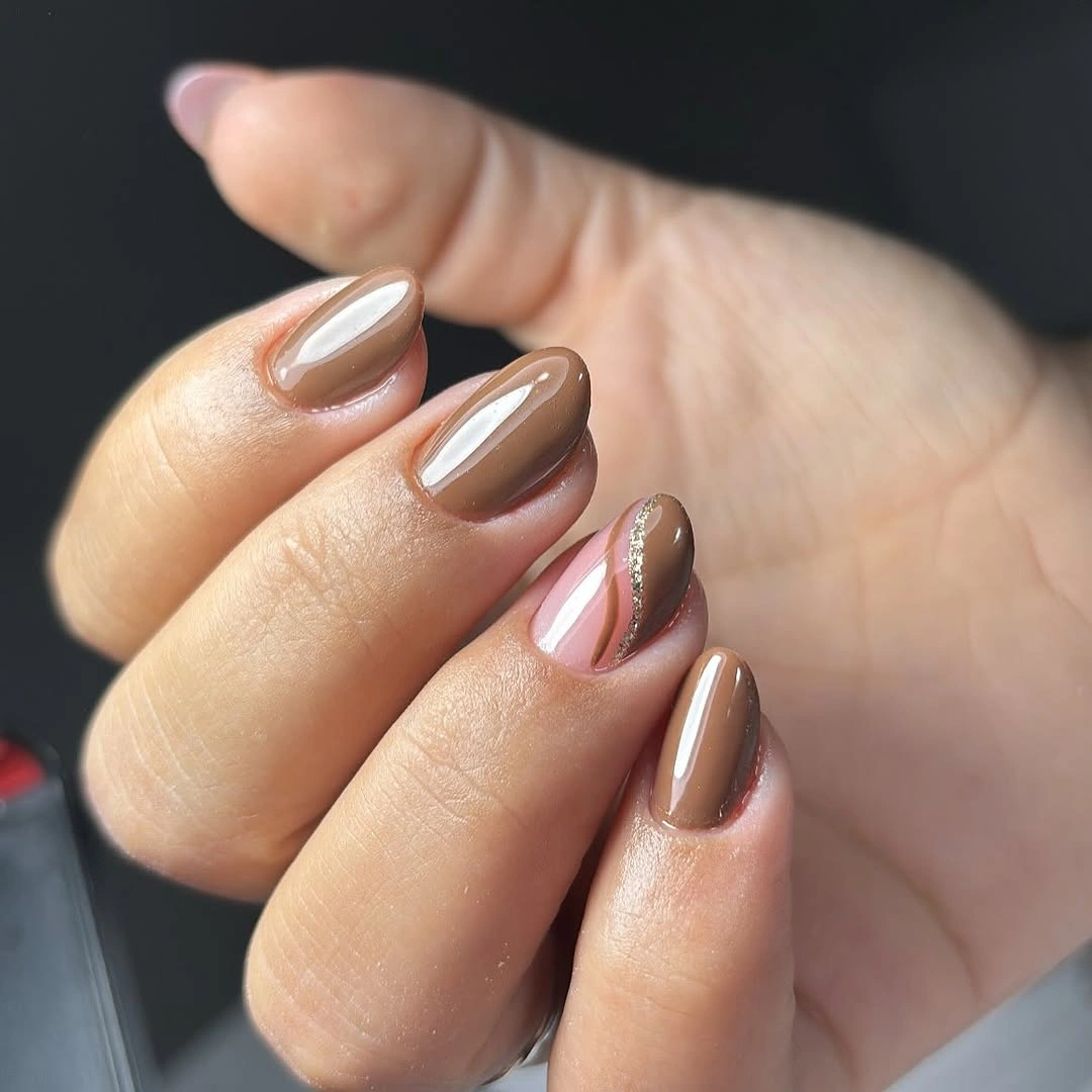 Short glossy taupe nails with a pink accent and metallic curved border