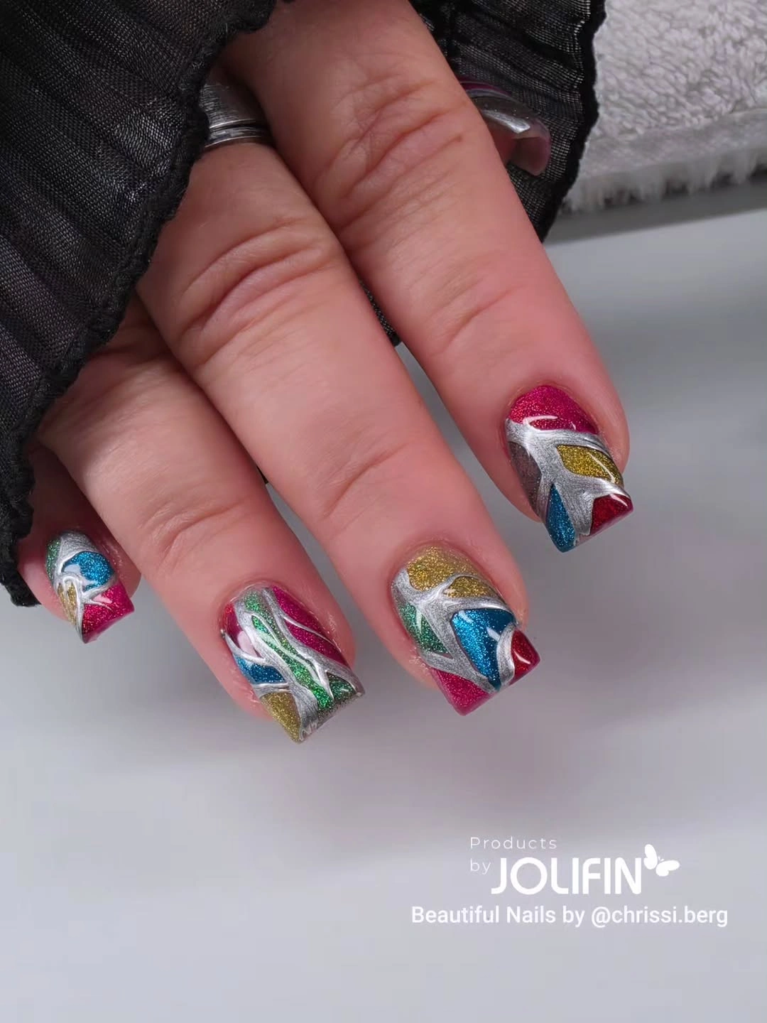 Short square nails with red blue green and gold glitter waves